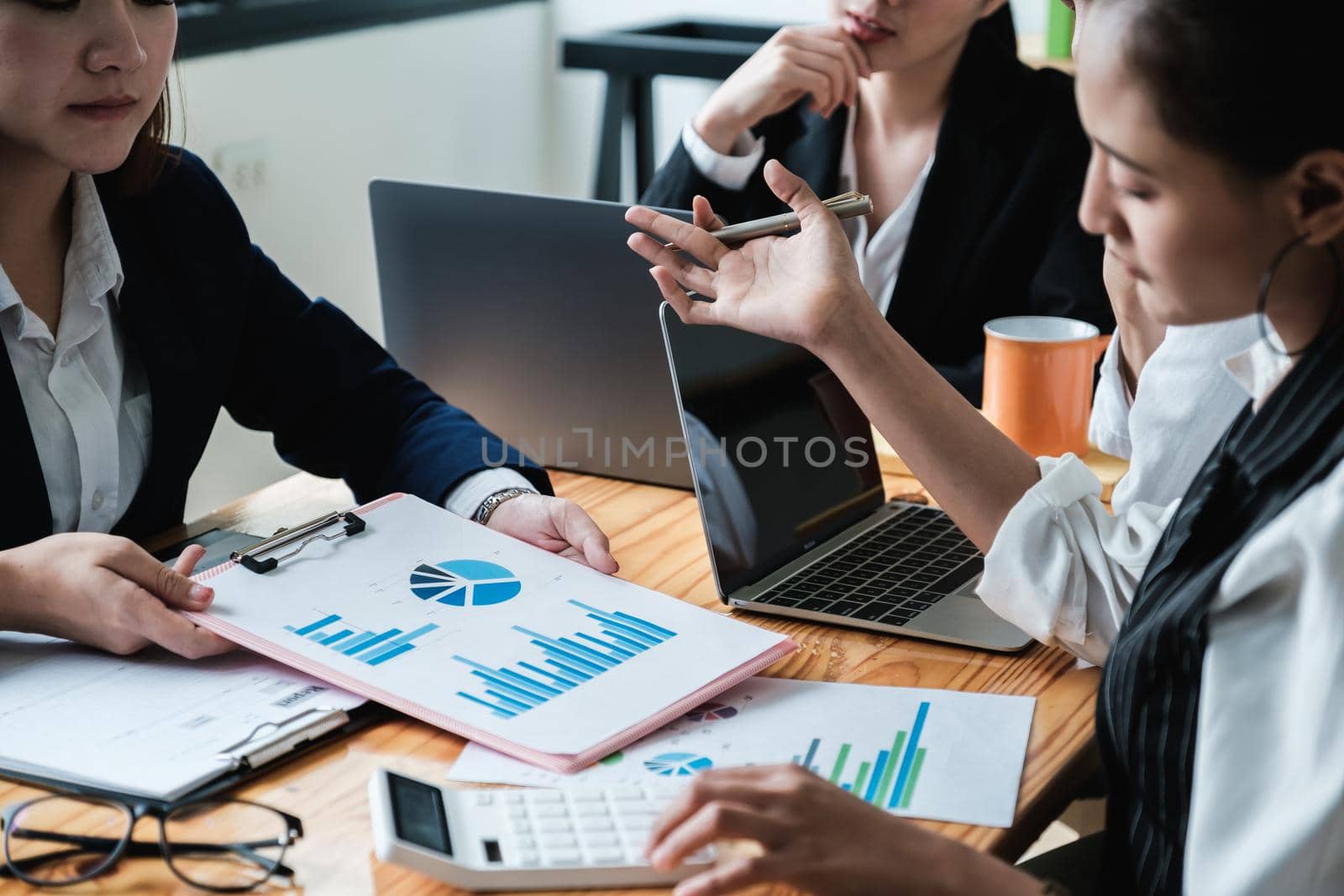 Close up Business woman and partner using calculator and laptop for calculating finance, tax, accounting, statistics and analytic research, group support and meeting concept.