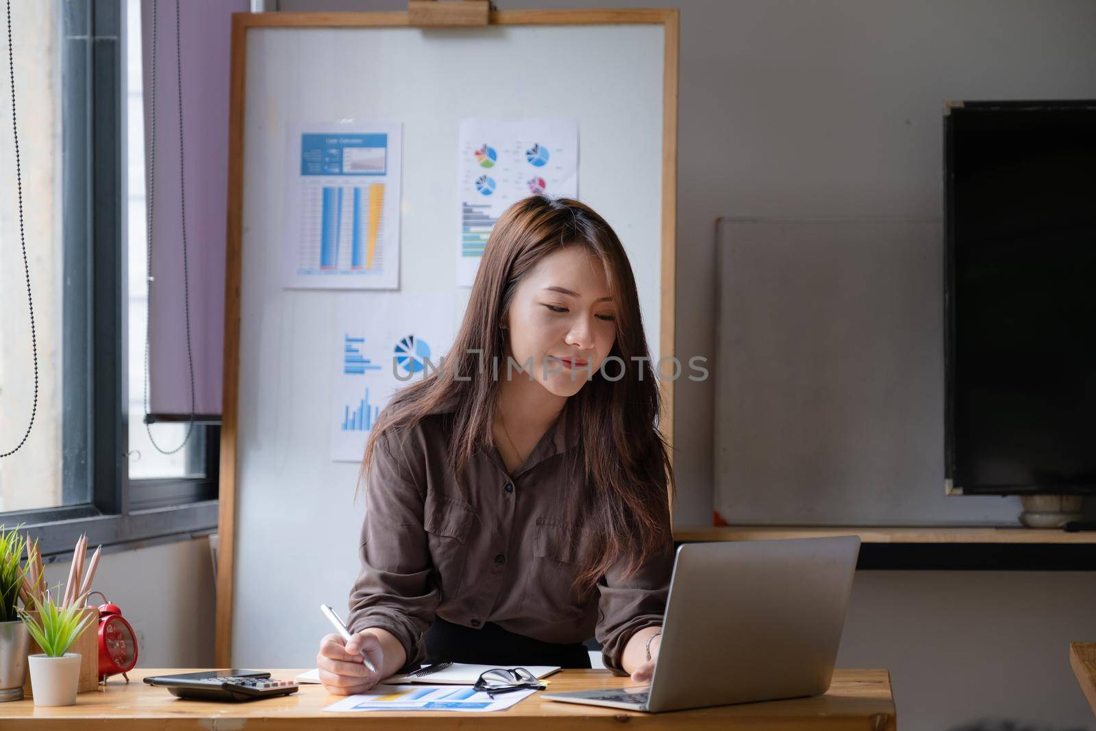 Portrait of business woman and smiling using video call on laptop computer with her parents. Quarantine and work from home concept