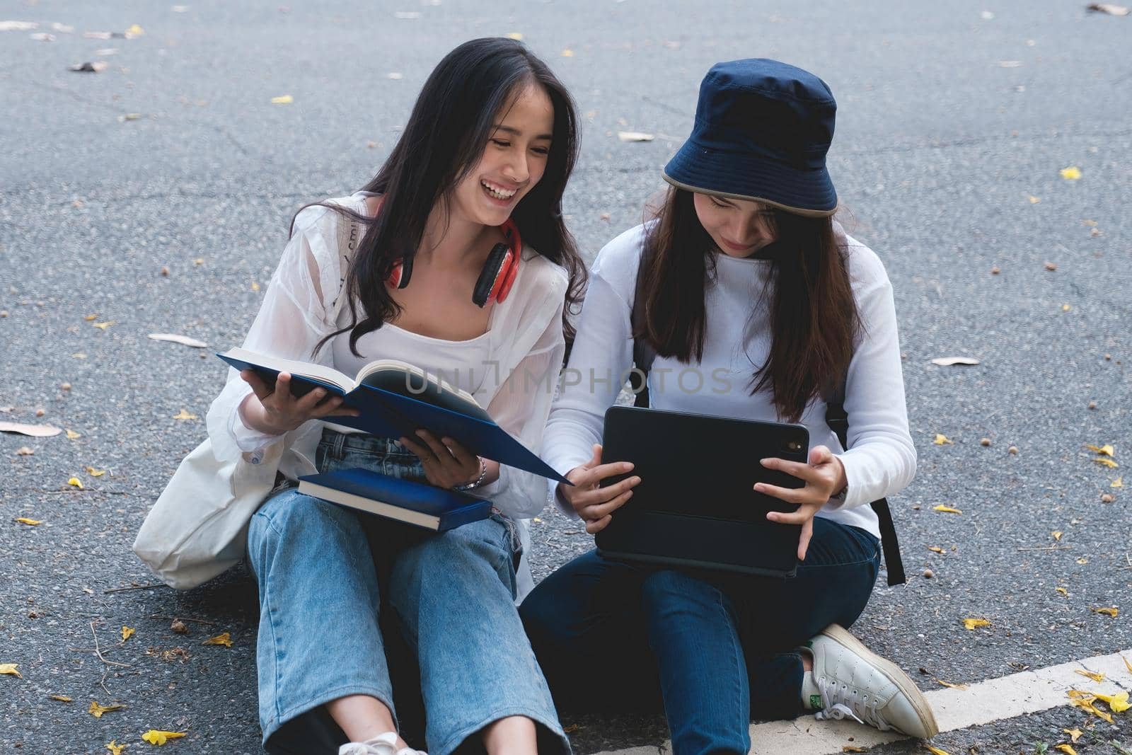 Two students are sitting in university during reading a book and communication. Study, education, university, college, graduate concept