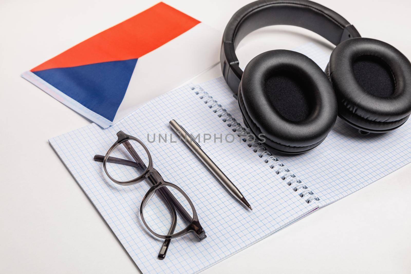 Learning foreign languages in the Czech Republic with audio recordings and headphones. Notepad, glasses, pen.