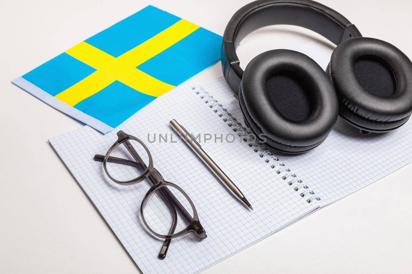 Learning foreign languages in Sweden with audio recordings and headphones. Notepad, glasses, pen.