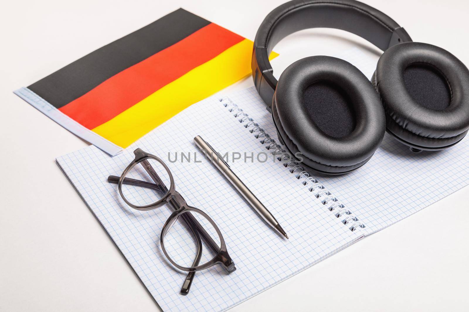 Learning foreign languages in Germany with audio recordings and headphones. Notepad, glasses, pen.