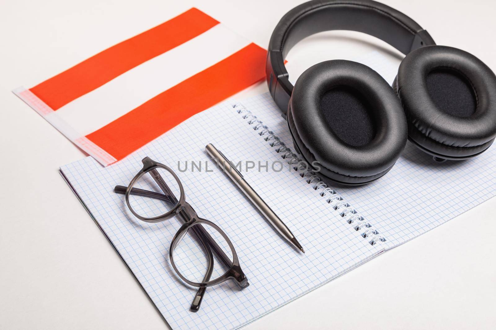 Learning foreign languages in Austria with audio recordings and headphones. Notepad, glasses, pen.
