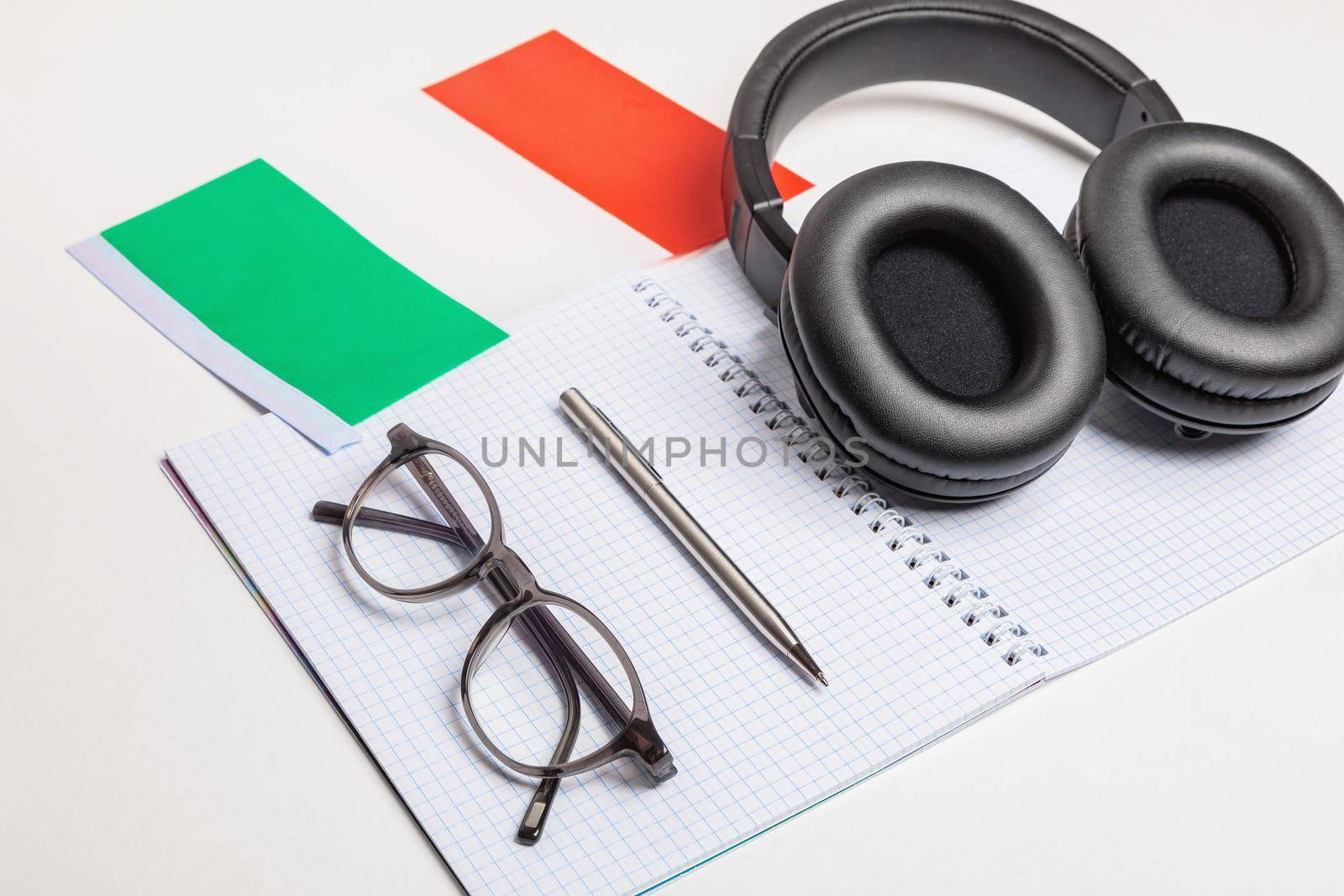 Learning foreign languages in Italy with audio recordings and headphones. Notepad, glasses, pen.