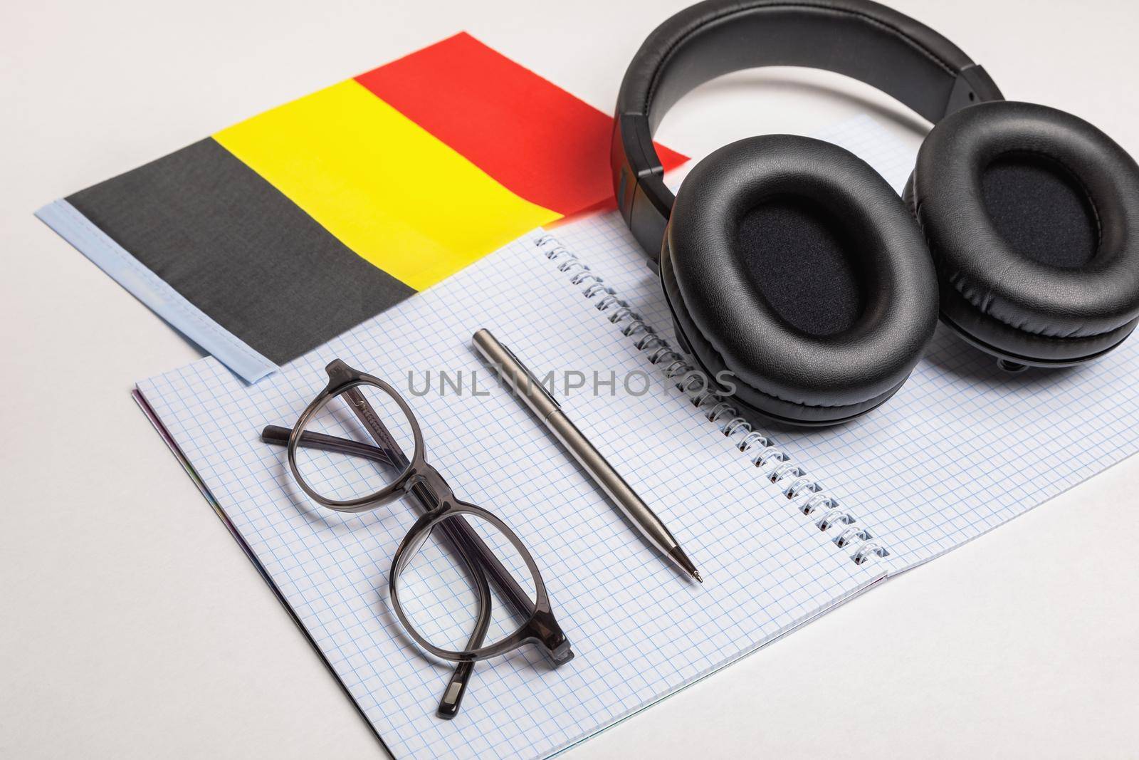 Learning foreign languages in Belgium with audio recordings and headphones. Notepad, glasses, pen.