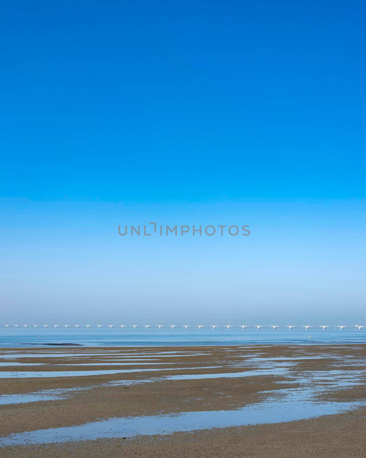 zeelandbrug under blue sky in water landscape of zeeland in the netherlands