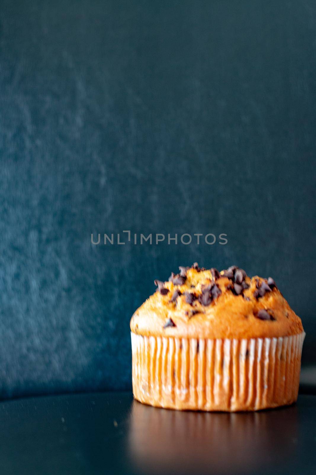 Chocolate chip muffin on a black background.