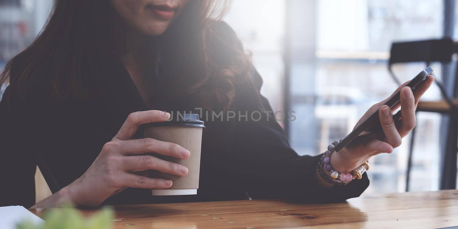 Closeup of Woman with a finger on the screen using a mobile phone in the office. Business woman hand using mobile smart phone and reading message via application