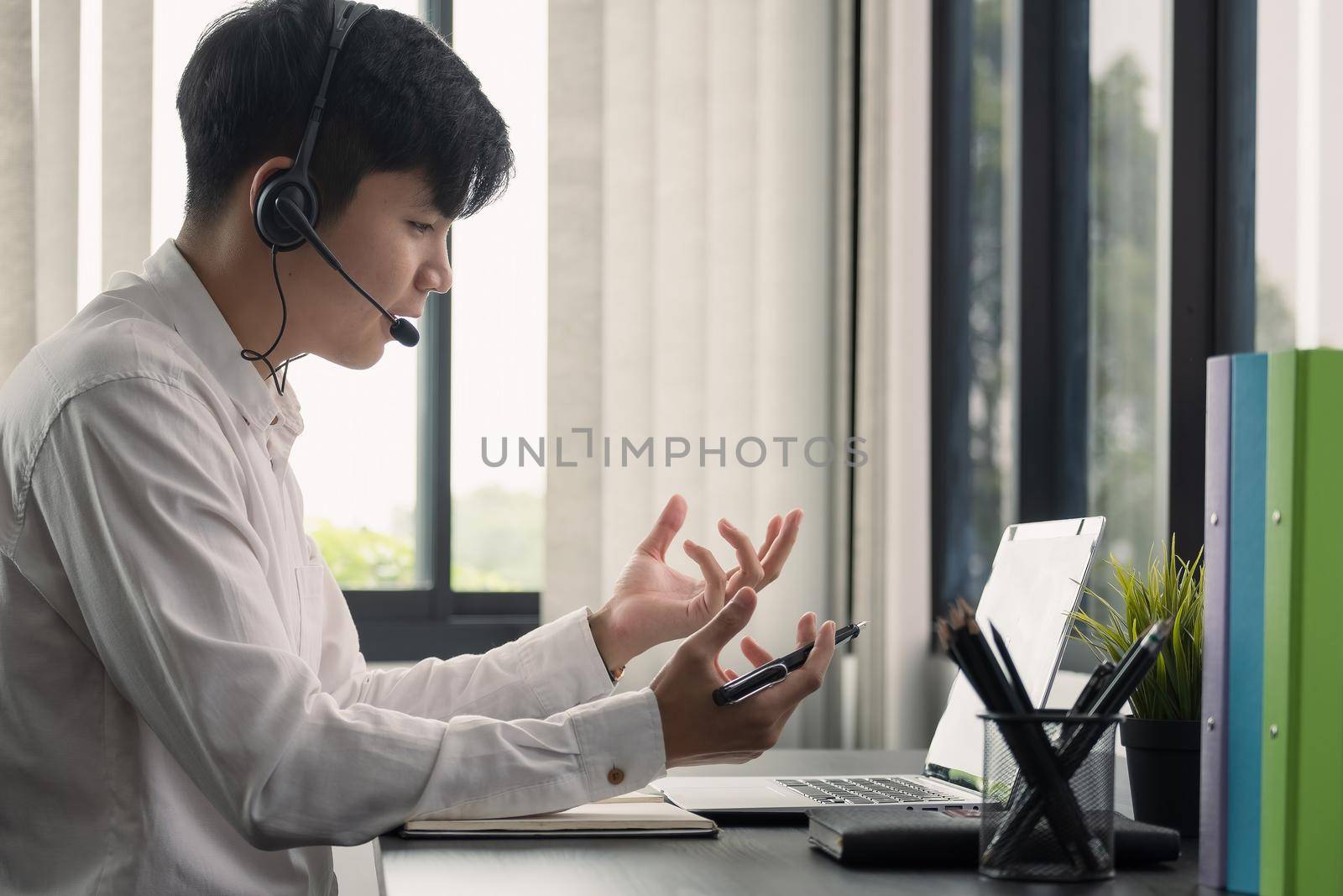 Young man student wear wireless headphone study online. She learn language listen lecture watch webinar write notes look at laptop, distant education