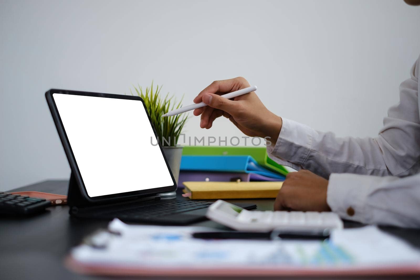 Cretive man in white dress smiling holding stylus pencil and coffee in home office. Work from home concept.