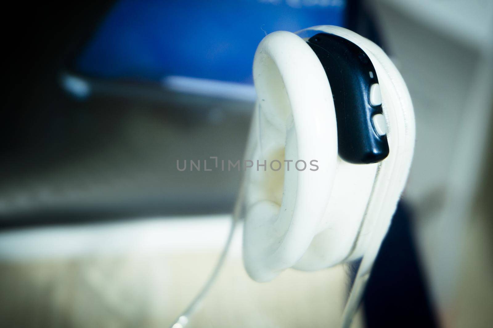 Plastic ear with modern hearing aid. No people