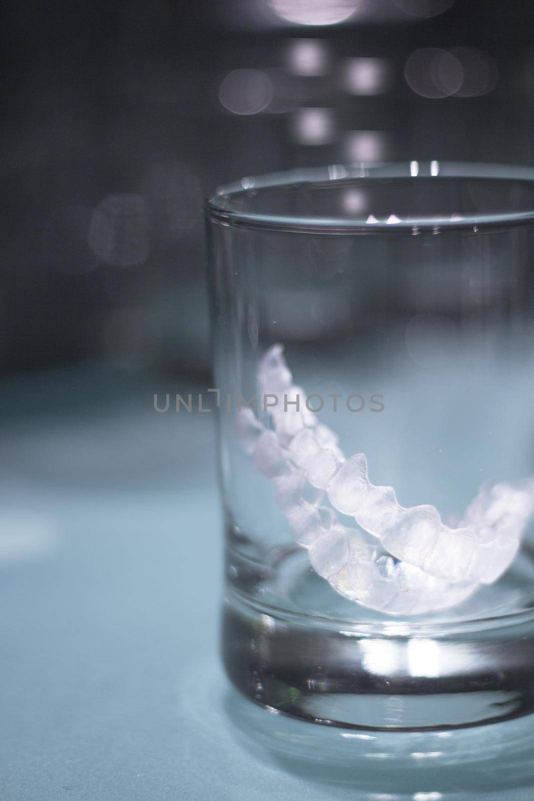 Transparent tooth aligner inside a crystal glass. No people