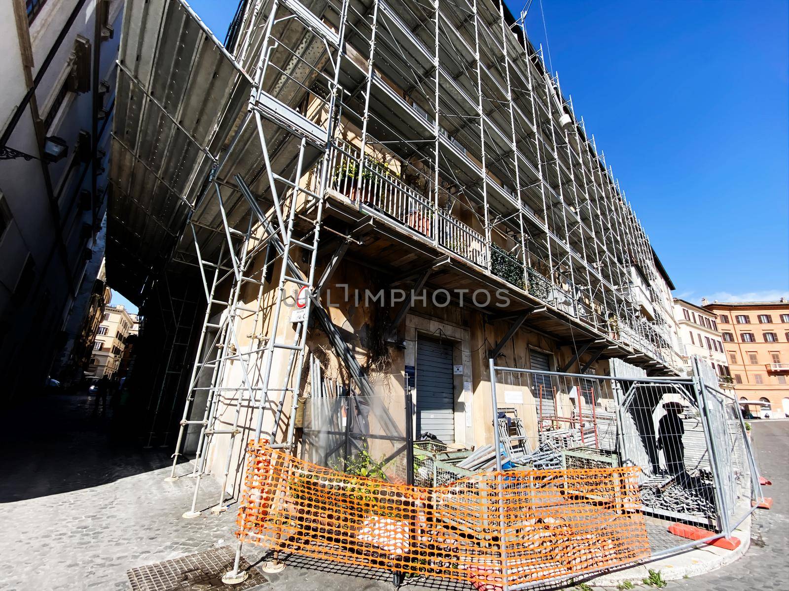 An ancient building undergoing renovation covered with steel scaffolding. Restoration and maintenance of ancient buildings. Carpentry and construction.