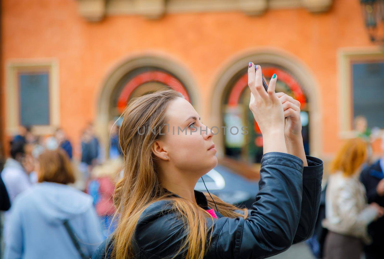 A young girl travels and takes pictures of the sights of the city on the phone.