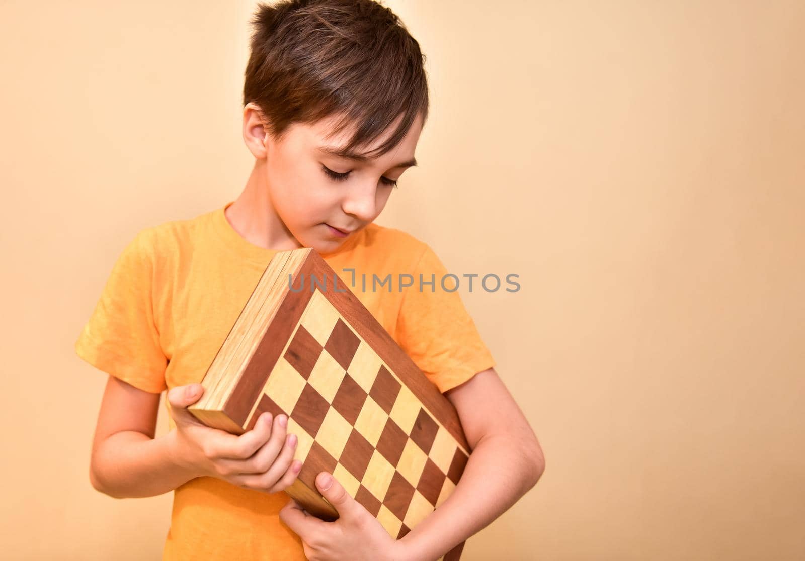 a boy holds a chessboard in his hands and looks at it by karpovkottt