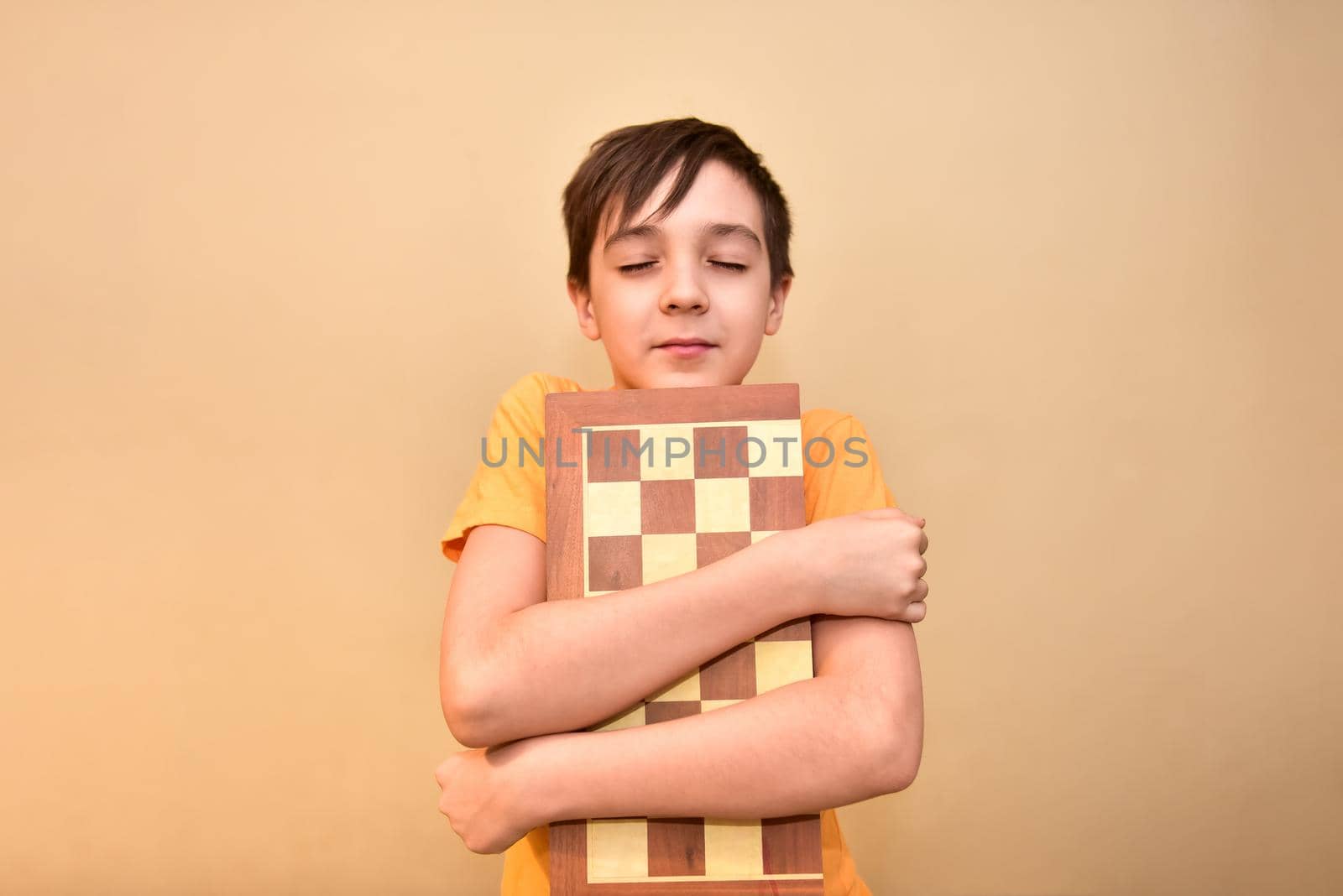 boy holds a chessboard in his hands and dreams and thinks about the game.