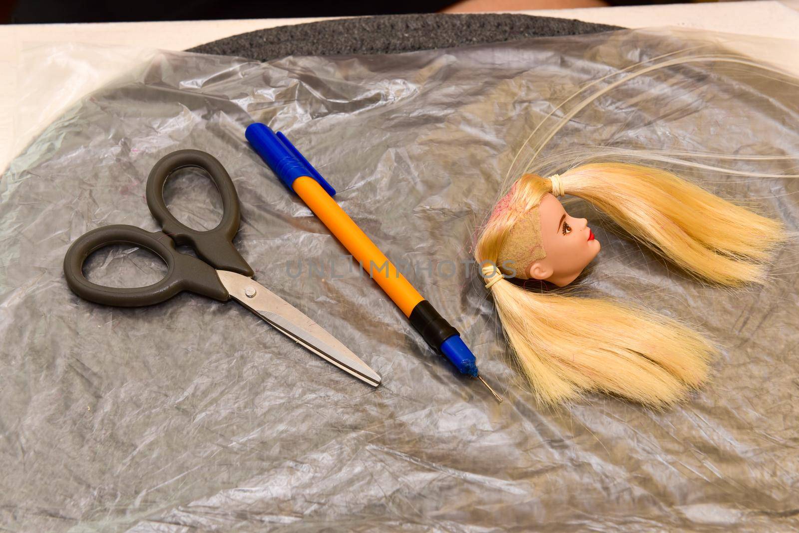 scissors and homemade tool on the table, how to make hair for a doll, hobby concept.