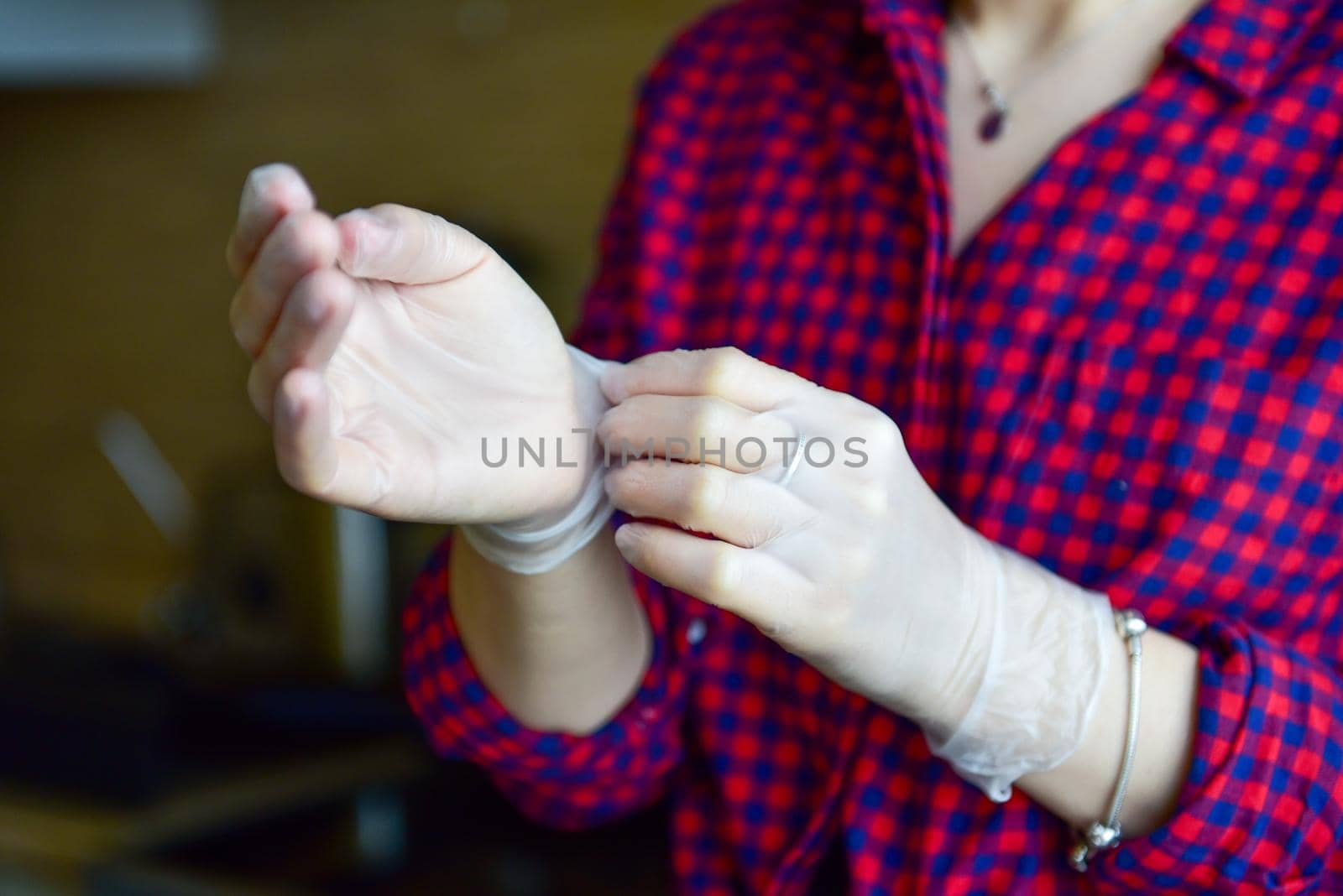 woman takes rubber gloves off her hands.