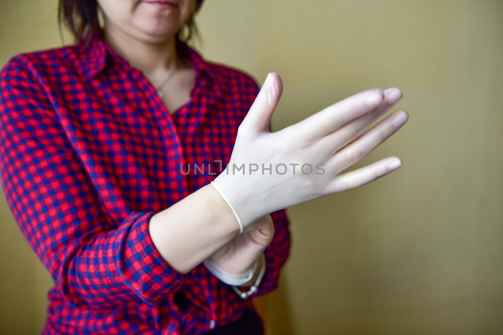 Personal protective equipment vinyl disposable gloves, woman puts her hands in gloves.