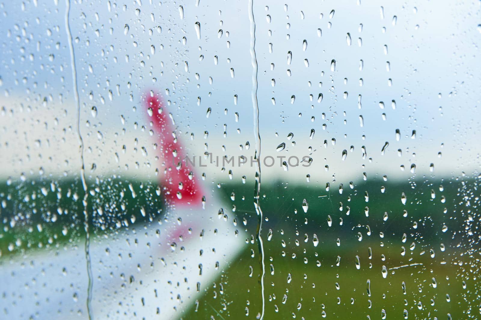 View through the foggy glass of an airplane before takeoff on a rainy day.