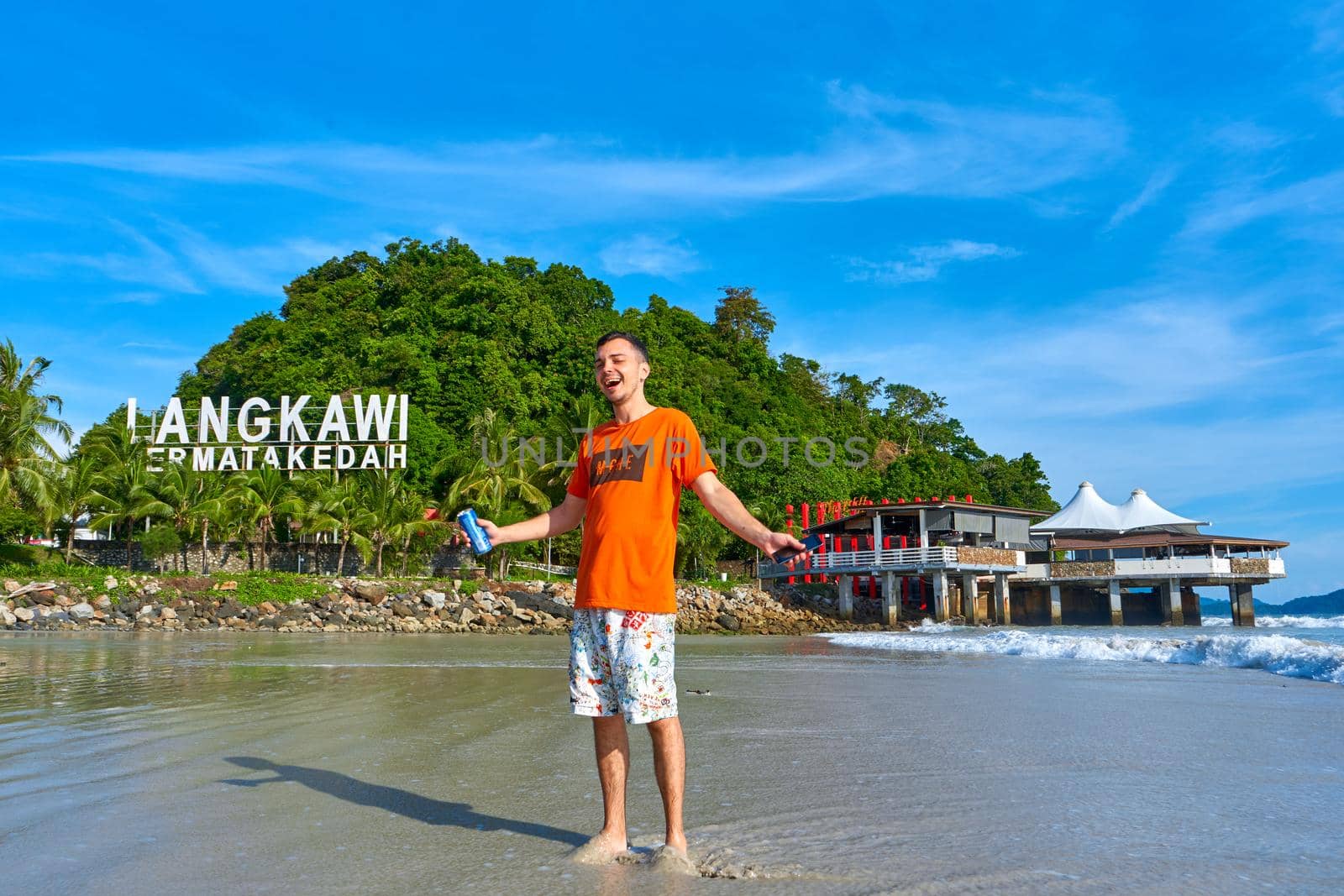 happy tourist guy on the central beach in Langkawi tropical island. Langkawi, Malaysia - 06.20.2020