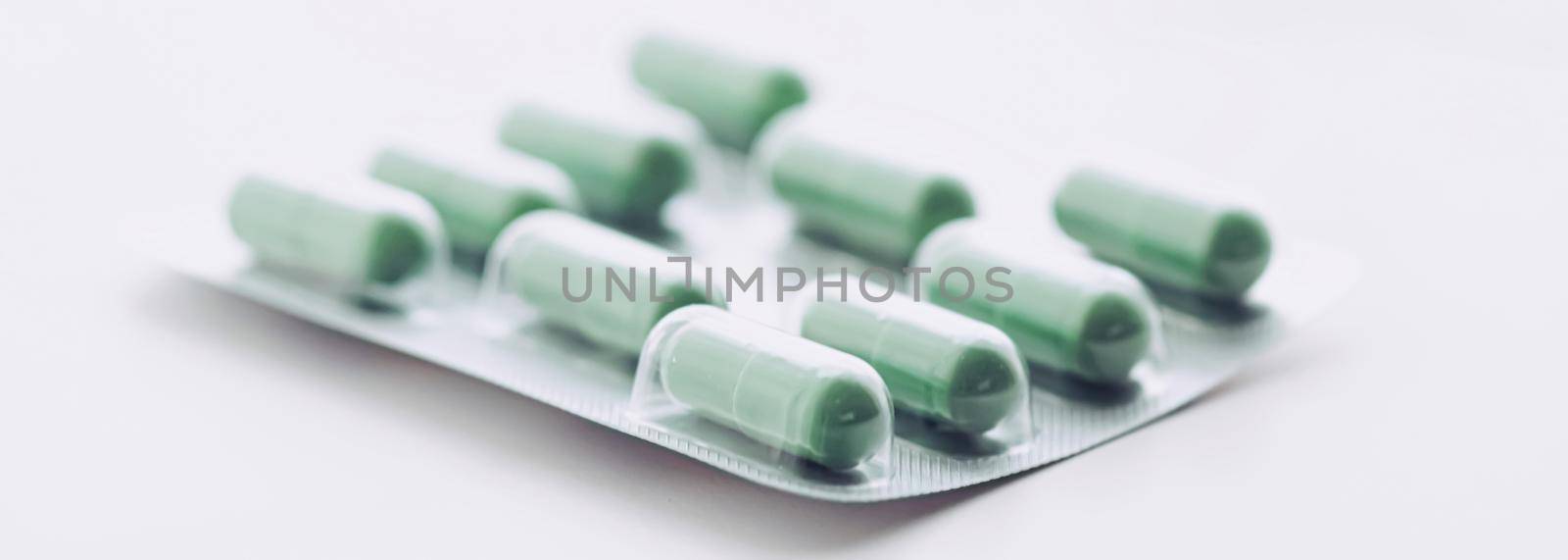 Green pills and capsules as nutrition supplement, wellness and healthcare concept