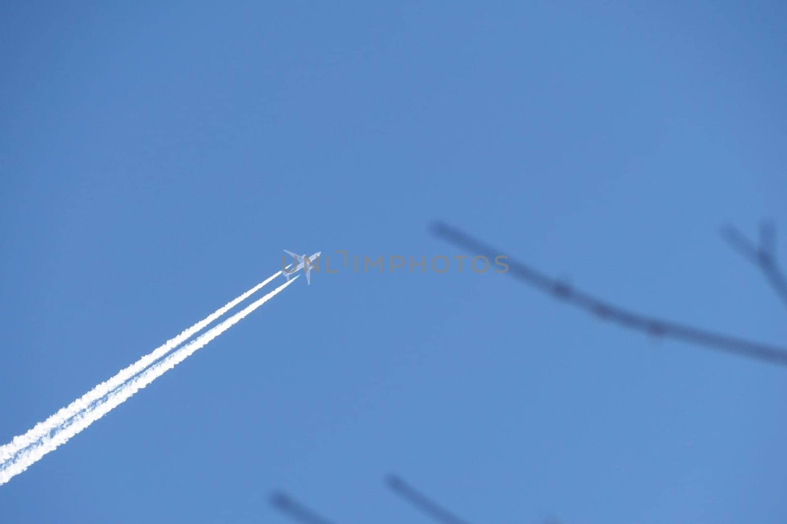 A jet plane in the sky. a double track from a jet plane in a blue sky. High quality photo