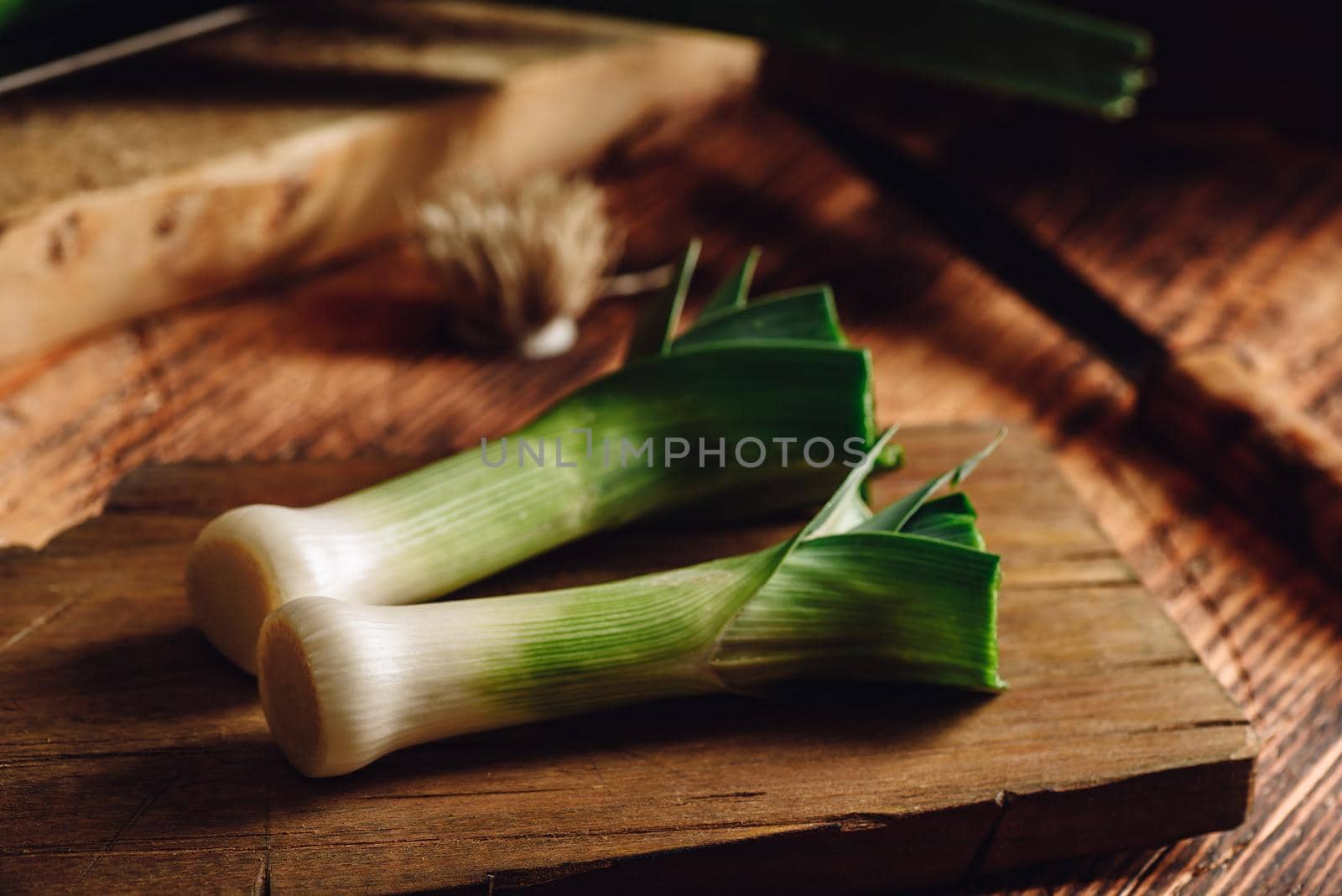 Fresh green leek on wooden cutting board