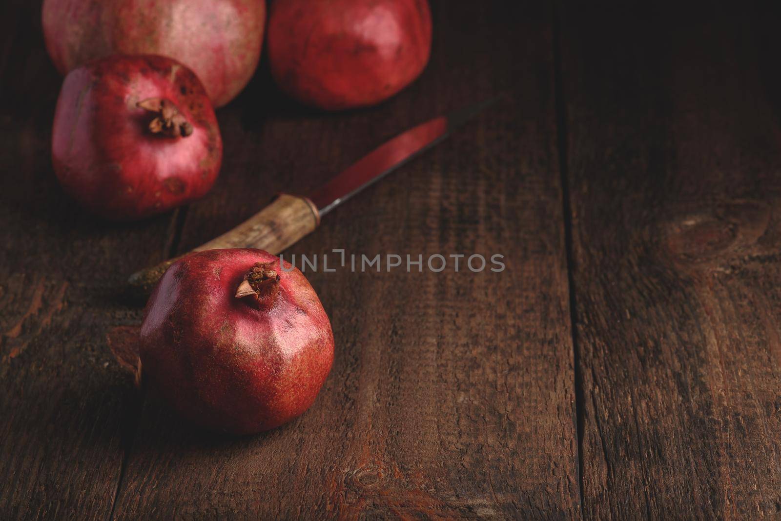 Ripe pomegranate fruits on rustic wooden surface