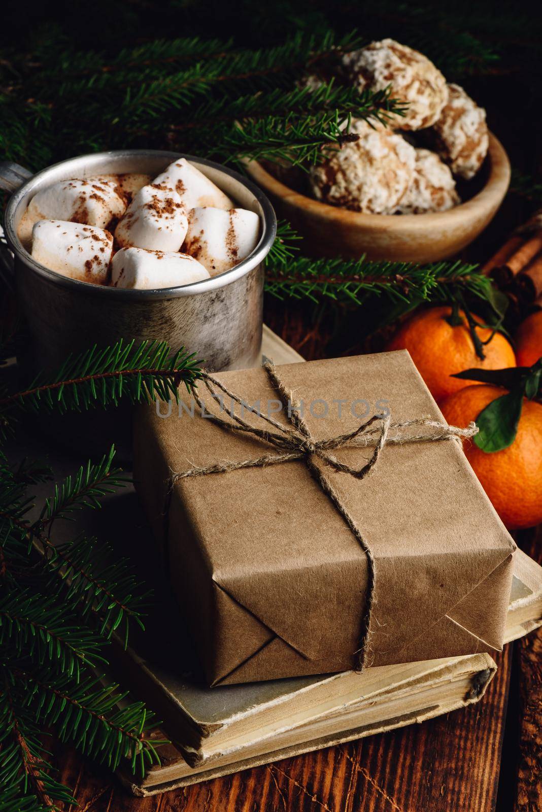 Christmas gift box wrapped with craft paper. Hot chocolate with marshmallows and gingerbread on background