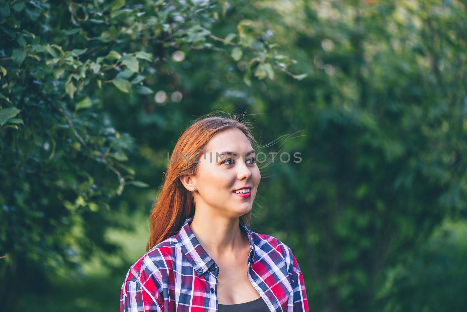 Smiling woman standing in the park by Seva_blsv