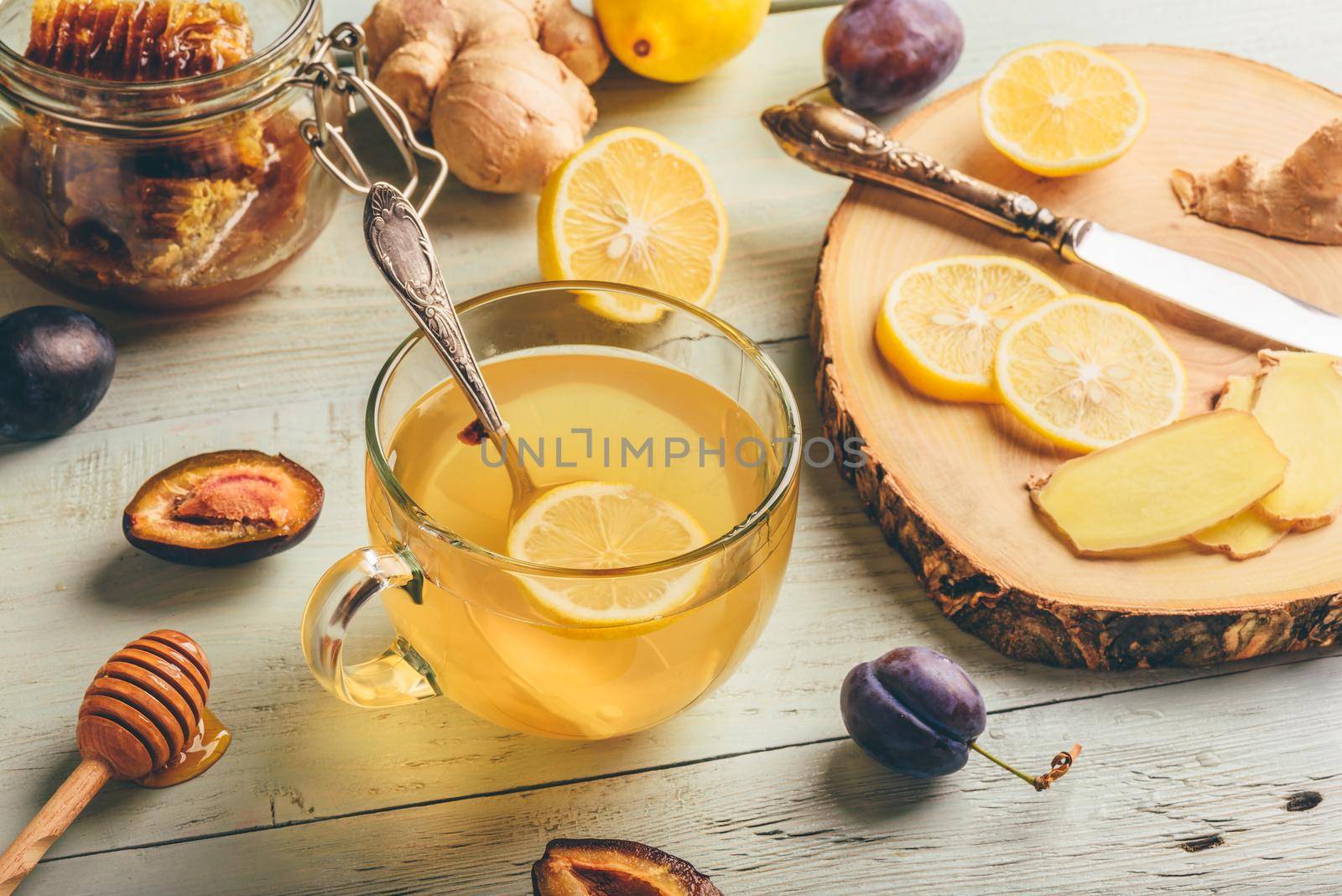 Cup of tea with lemon, honey and ginger over wooden surface