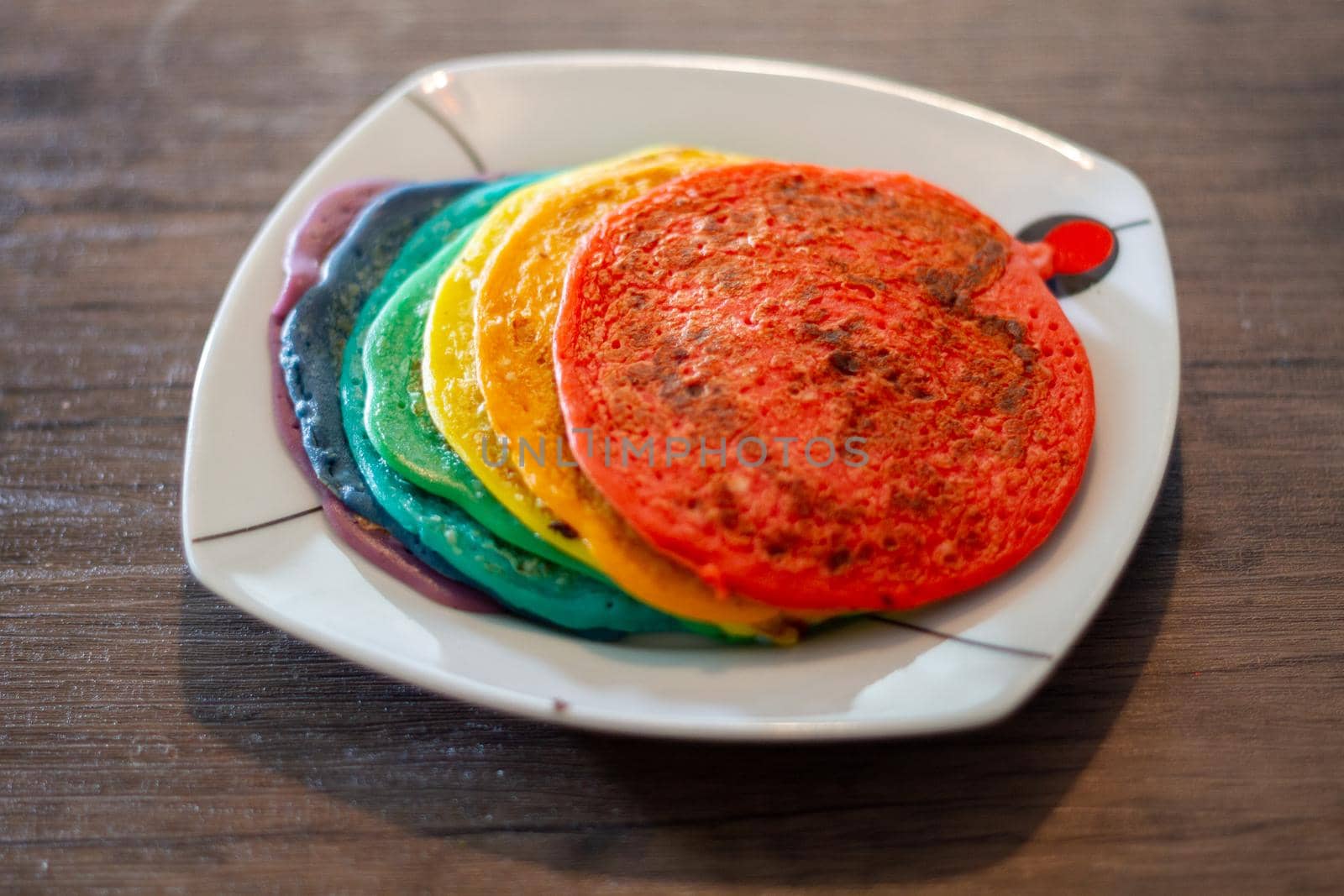 Dish With A Stack Of Rainbow Coloured Pancakes