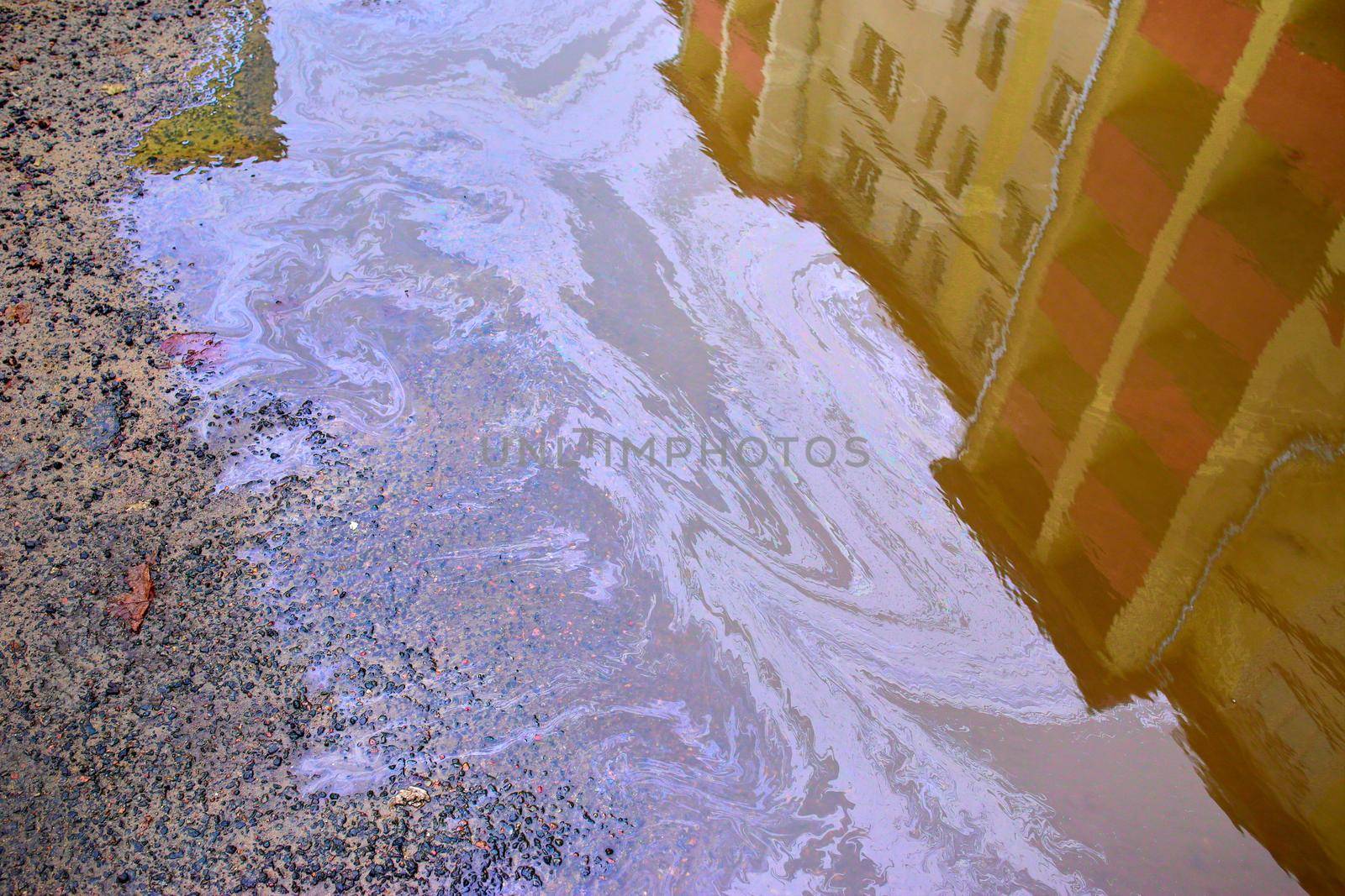 Beautiful abstract colorful background, stains of motor oil in a puddle with reflection of a building in blur, marbling texture