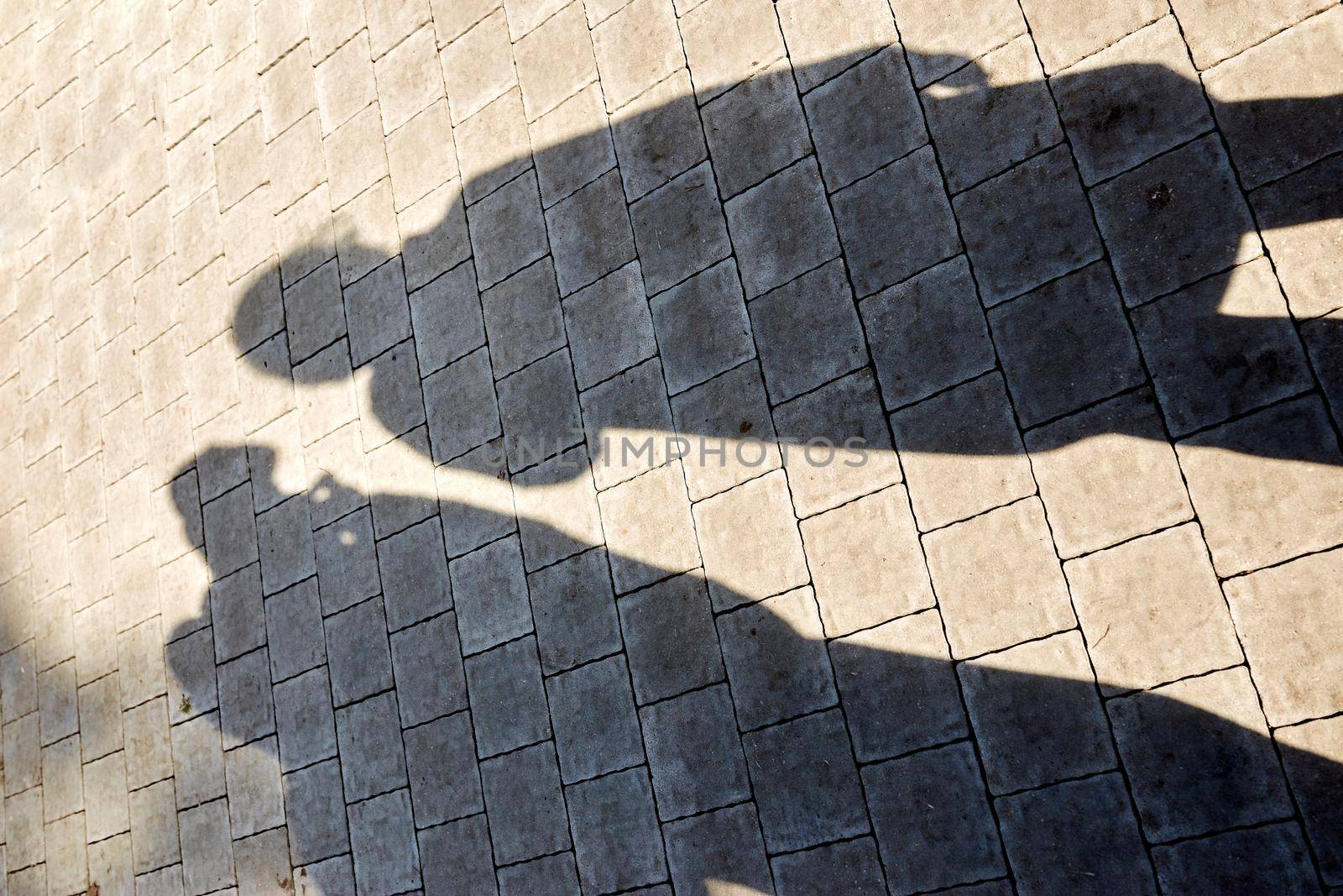 two shadows from the figures on the paving slabs