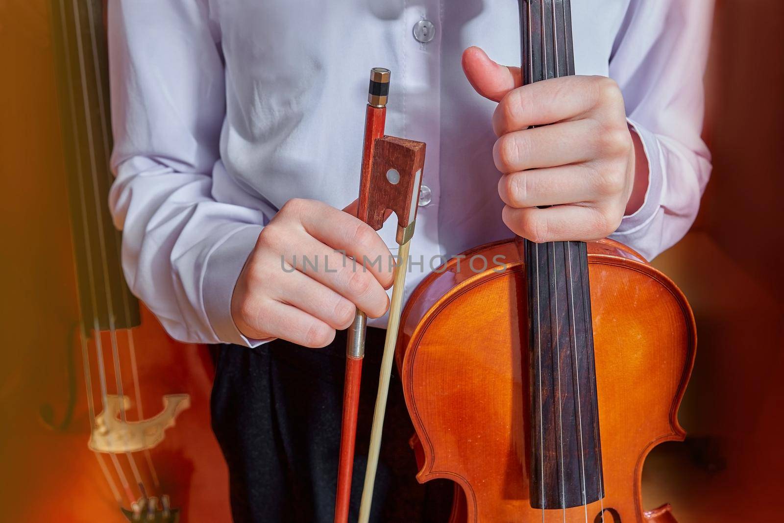 children's hands hold a violin and a bow