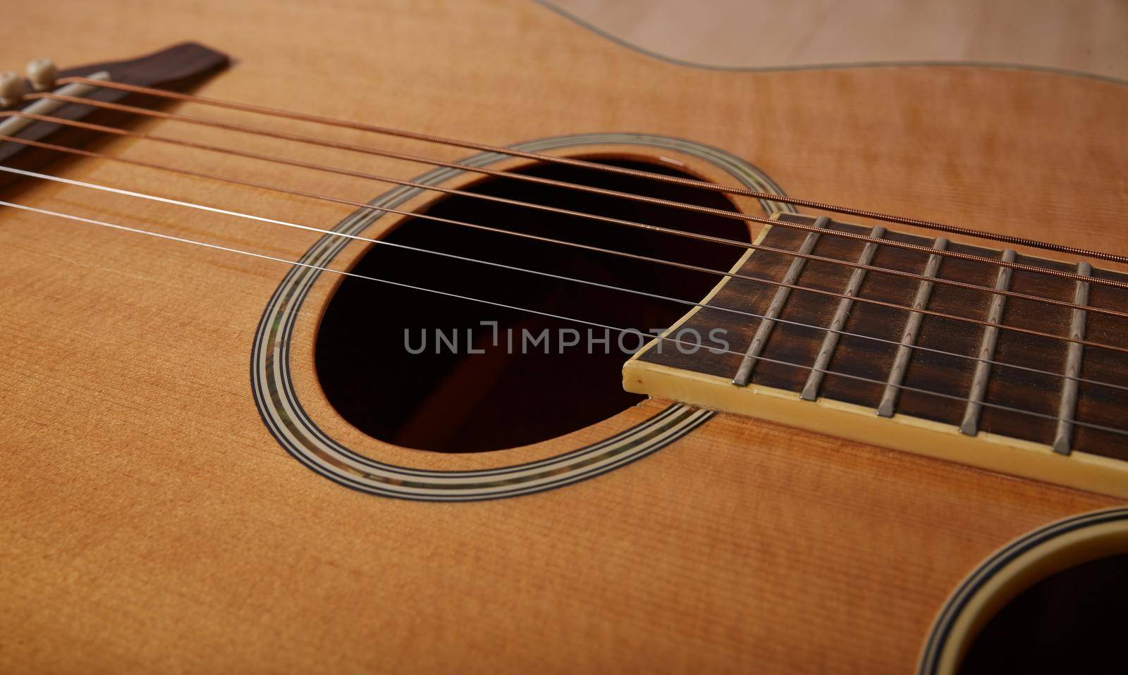The bridge and strings of and acoustic guitar. Close up. Selective focus
