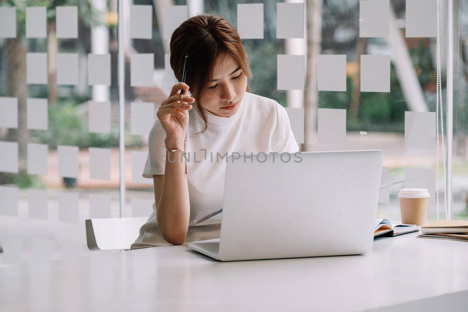 Pensive stressful female employee examining reports while working on complicated project at home.