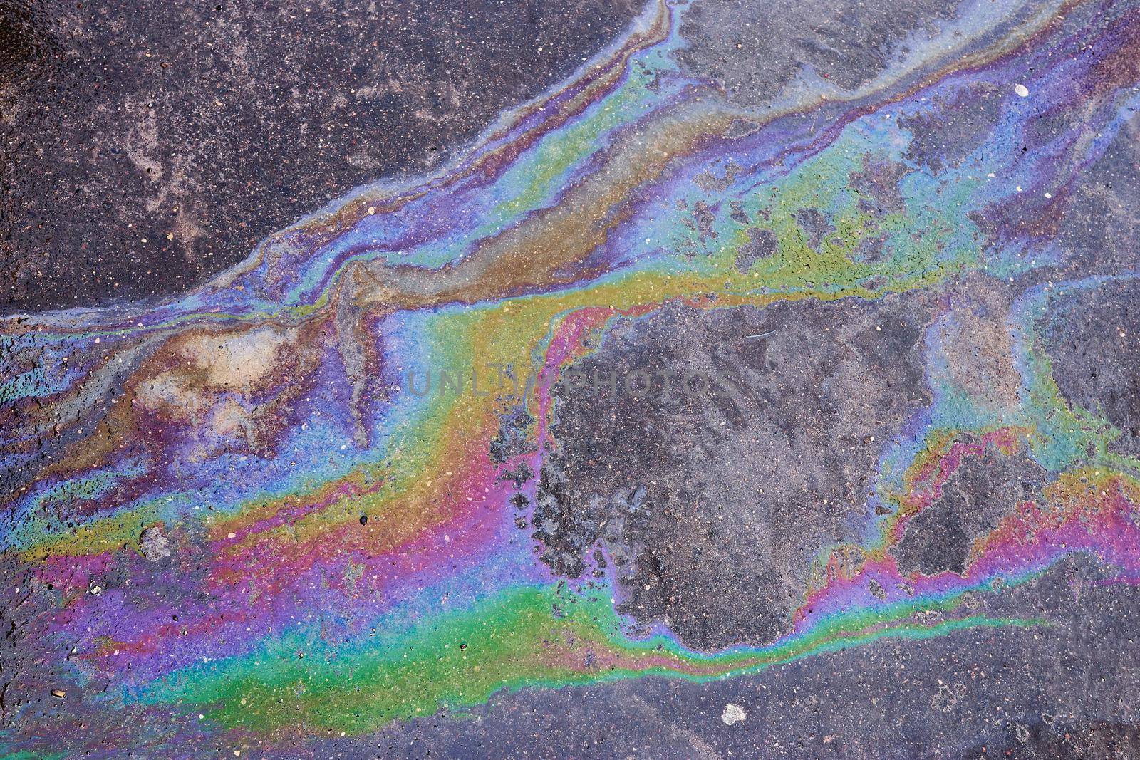 Oil stain on Asphalt, color Gasoline fuel spots on Asphalt Road as Texture or Background. Iridescent stains of gasoline.