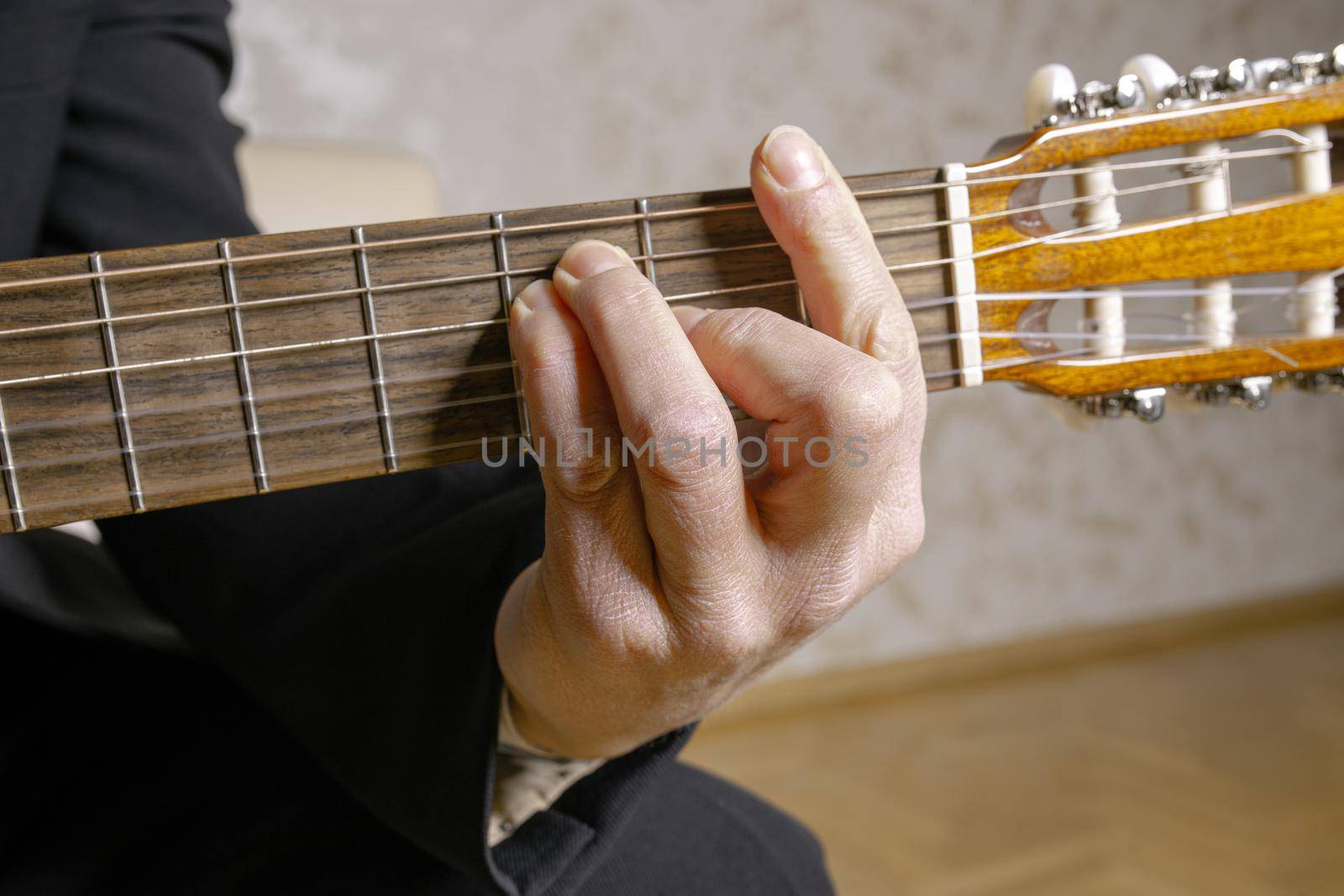 Close-Up Of Hand Person Playing Guitar Sitting