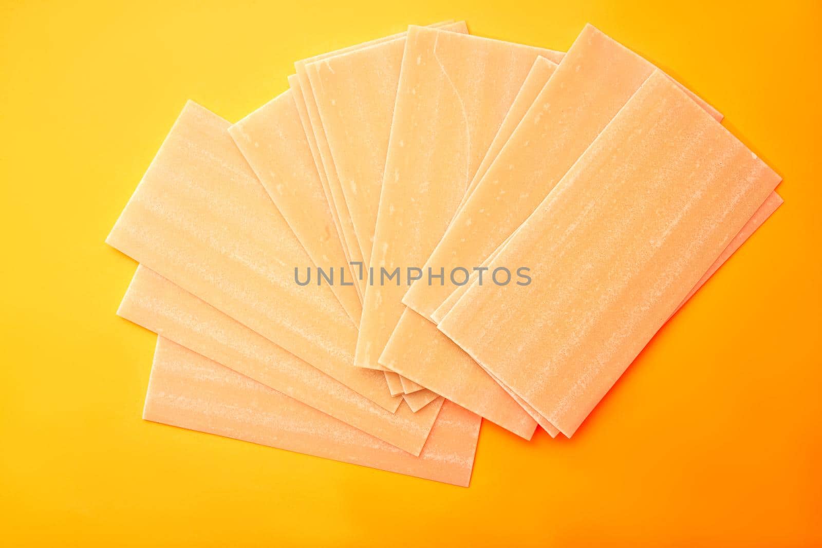 Raw lasagna pasta on white orange background