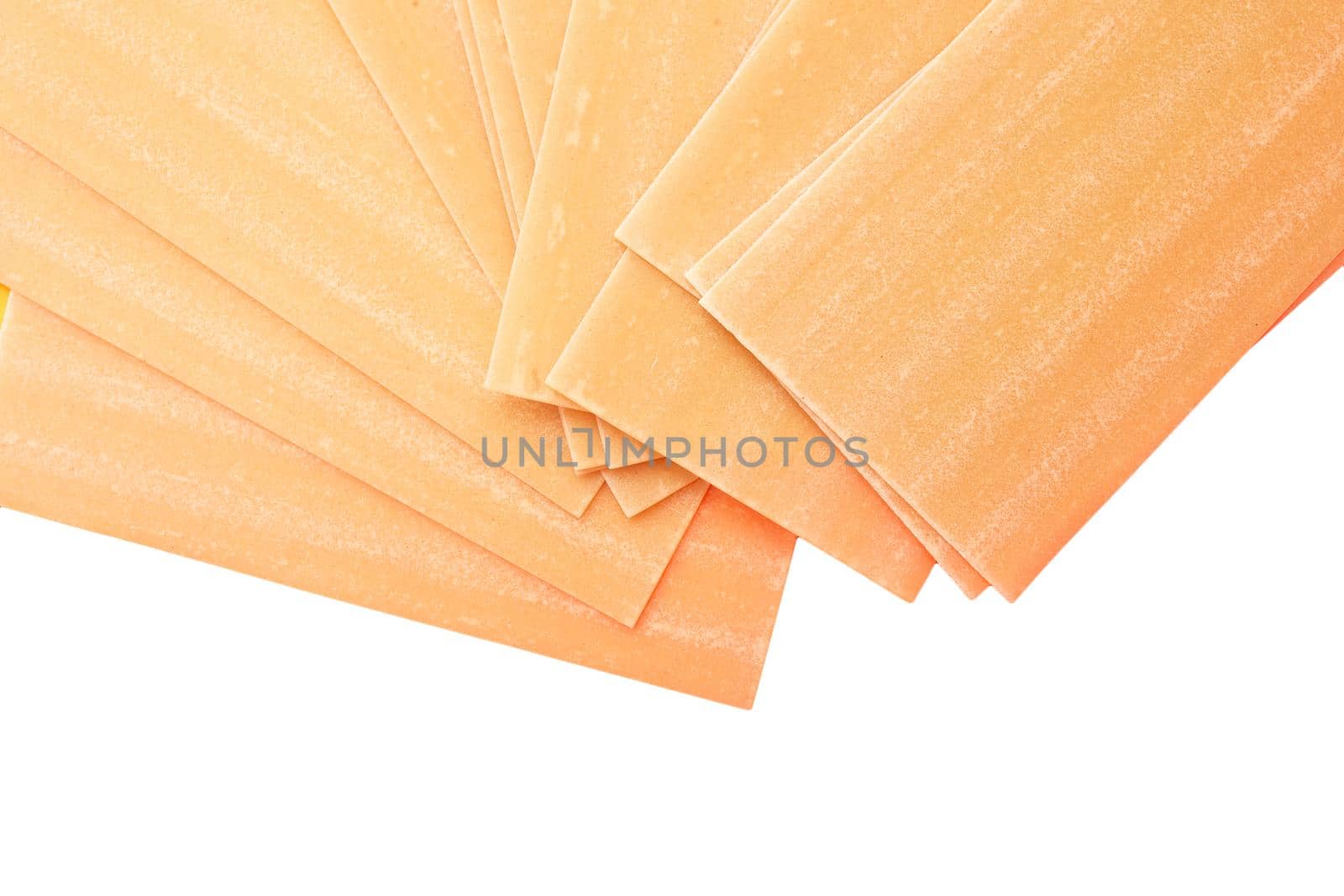 Uncooked lasagna pasta isolated on white background. Pile of dried uncooked lasagna pasta sheets