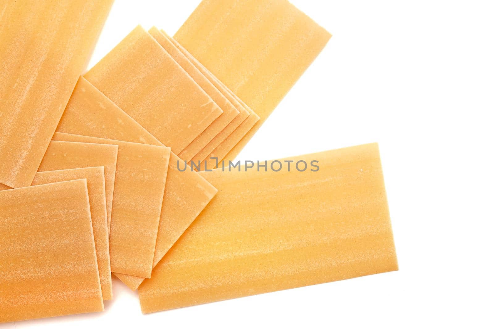 Pile of dried lasagna pasta sheets isolated over the white background