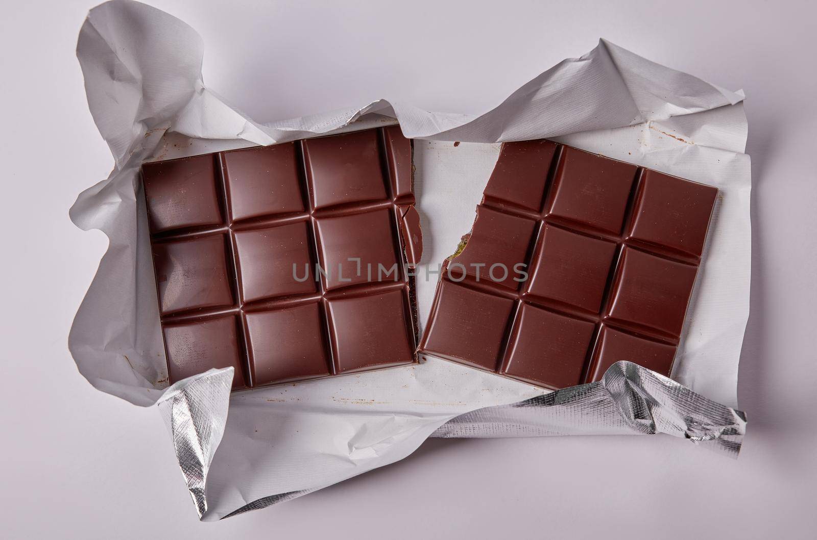 dark chocolate bar divided into two halves on foil