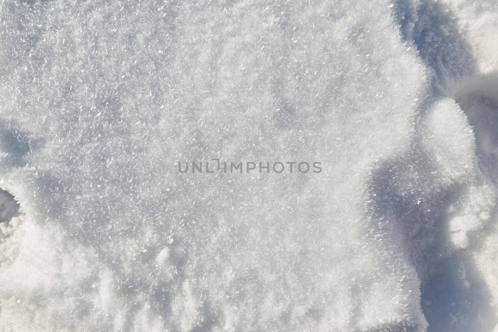 Snow texture background, natural white snow powder in winter on a bright sunny day. Background, macro of snow with crystals