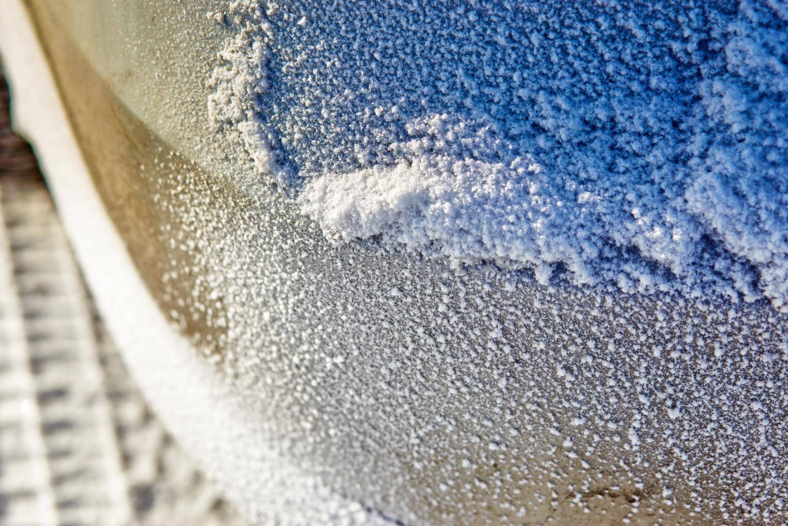 snow texture on the bumper of the car. Selective focus