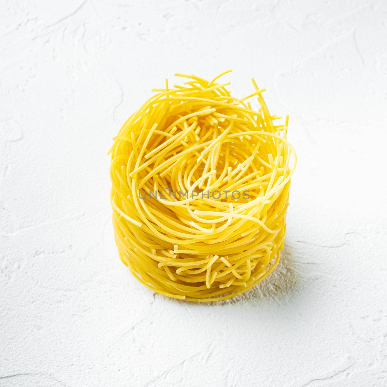 Dried taglierini , on white stone surface, square format by Ilianesolenyi