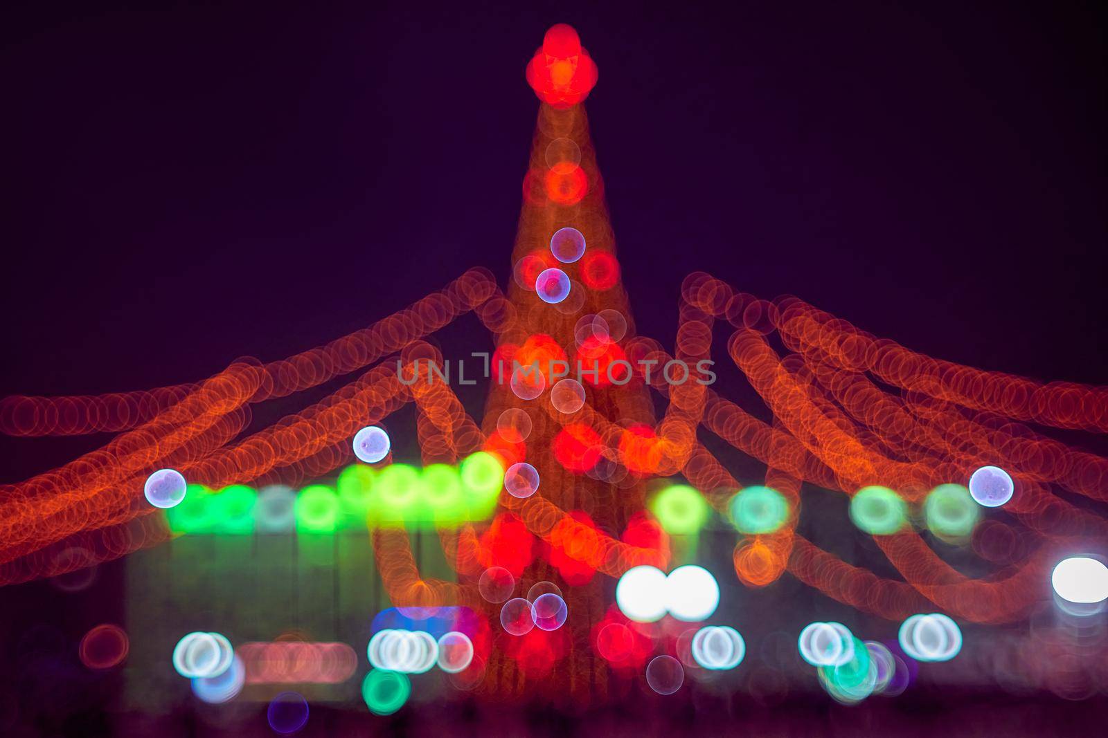 Abstract christmas background with christmas tree with decorations, defocused bokeh lights outdoors. Beautiful sparkling backdrop, texture.