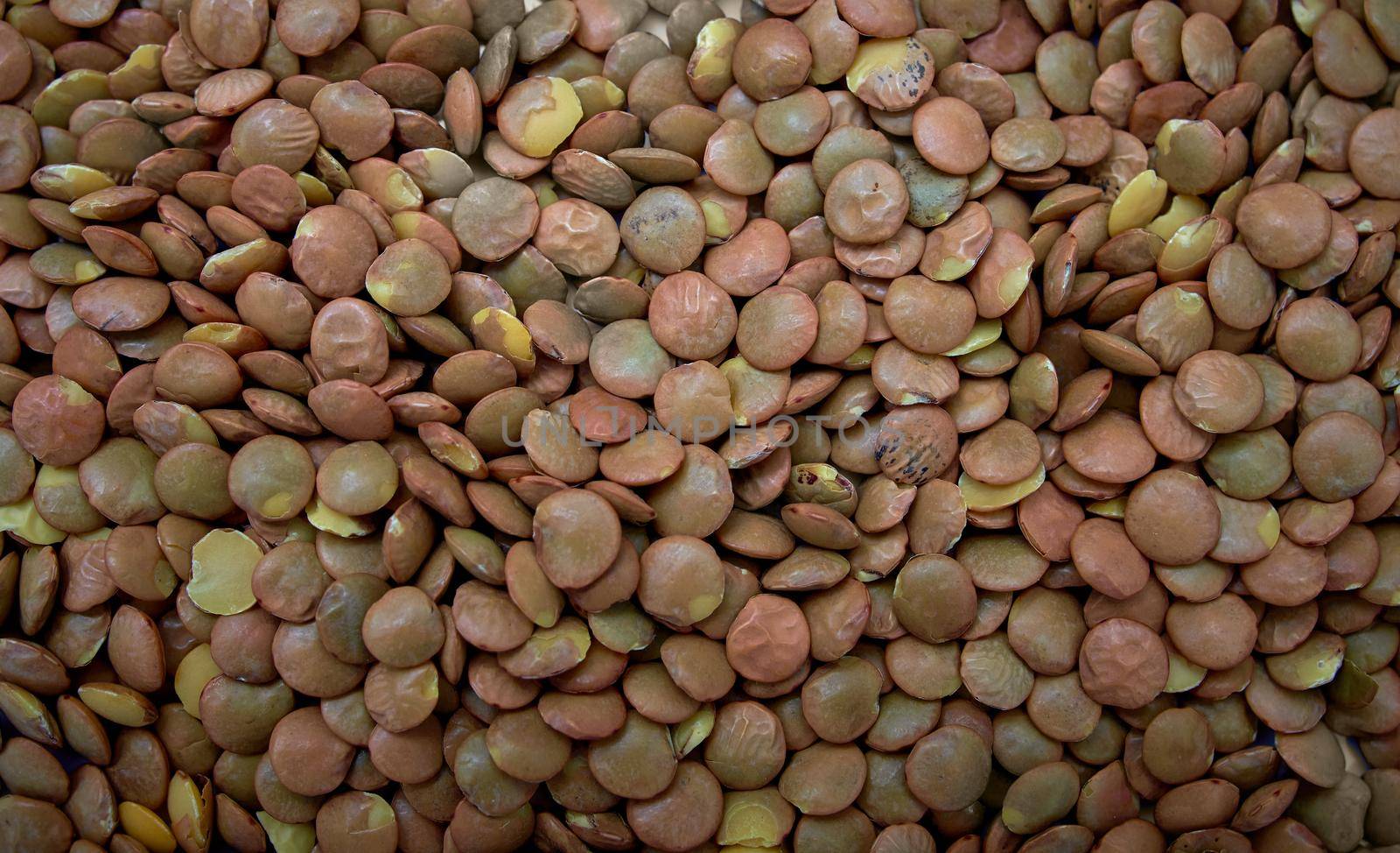 Heap of brown lentil texture as background. Top view.