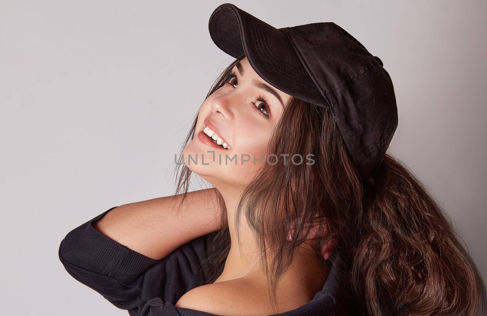 Very attractive young woman in a cap posing in studio